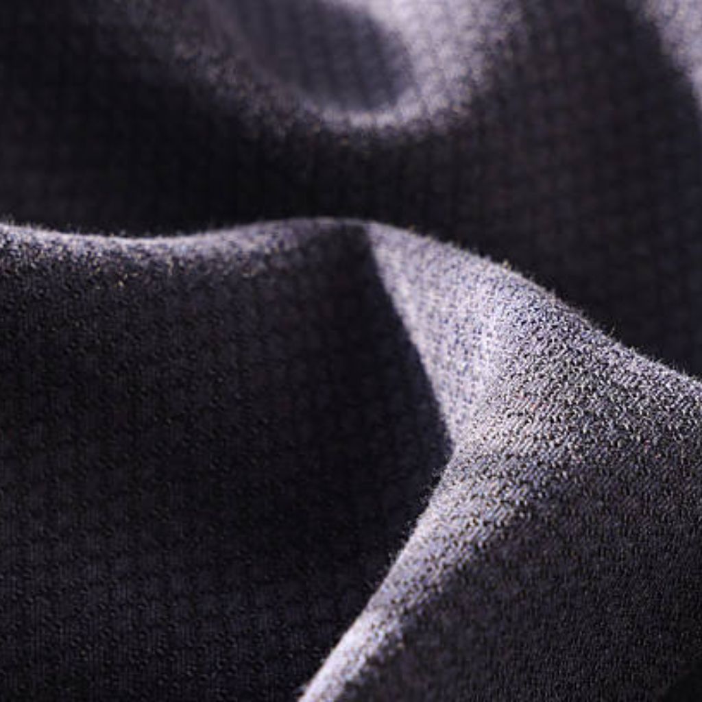 Close-up of textured dark gray fabric with a curved fold, showing a rough, woven surface.
Flex Motion Stretch Fabric: