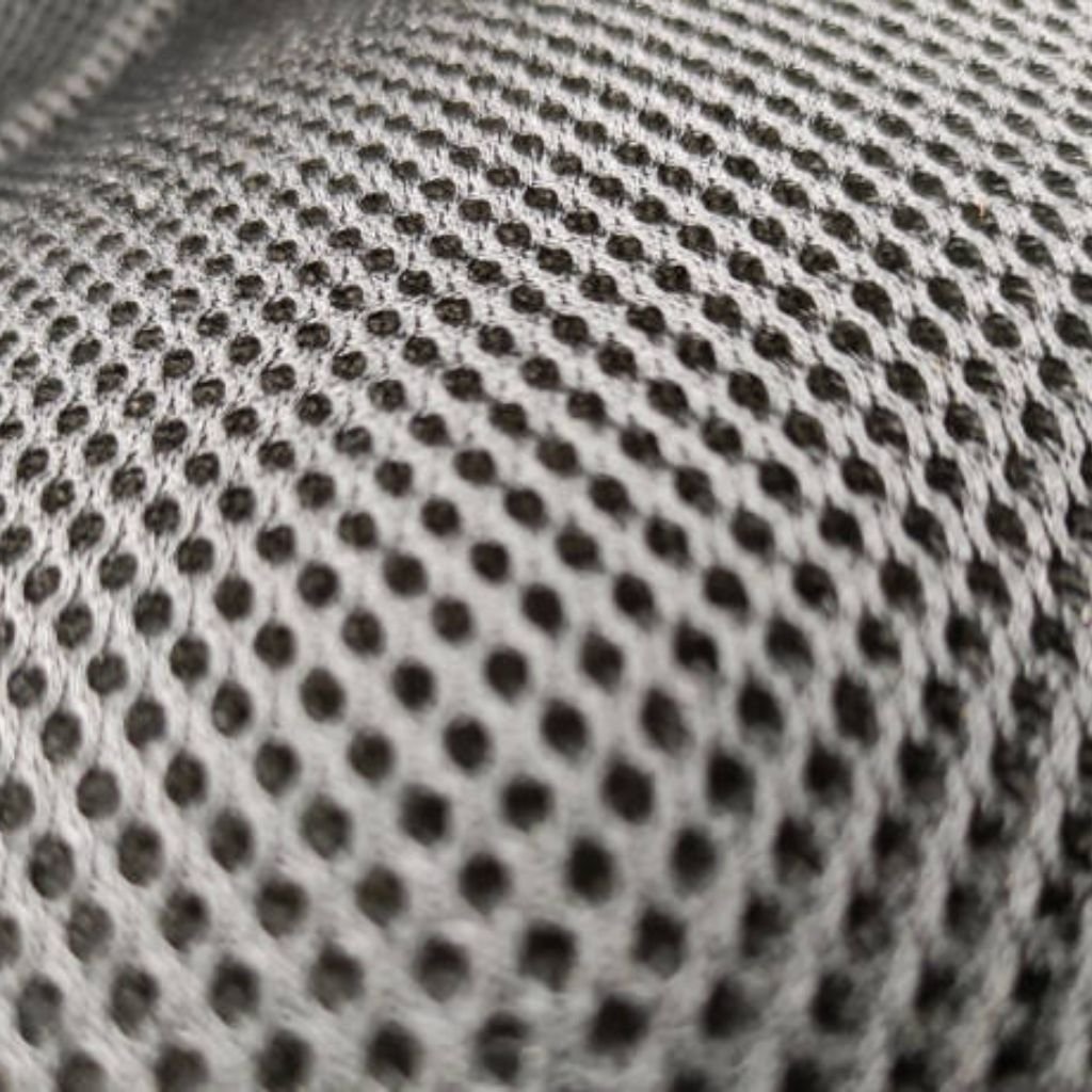 Close-up of light gray mesh fabric with a regular pattern of small, dark circular holes. The fabric has a slight sheen and shallow depth of field.
Cool Max Air Flow Mesh Fabric: