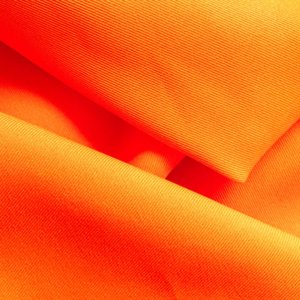 “Close-up of vibrant orange fabric, folded with visible ribbed texture and soft shadows.”

Power Stretch Active Fabric: