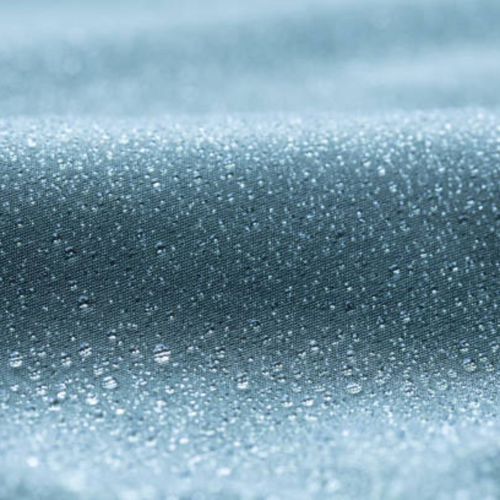 Alt text: Close-up of teal, water-resistant fabric with water droplets beadily on the surface; subtle texture, folds create depth.Chill Tech Moisture Control Fabric:
