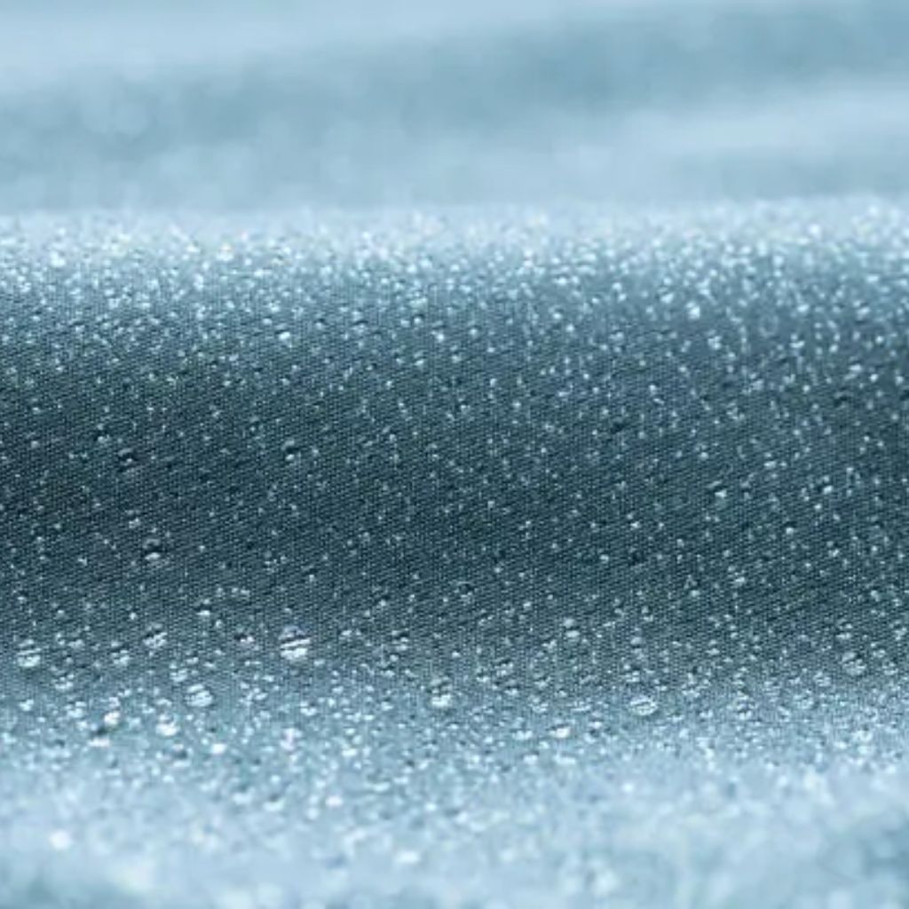 Alt text: “Close-up of a blue knit fabric with a slightly textured surface, resembling a soft winter jacket material.”
Frost Flex Active Fabric:
