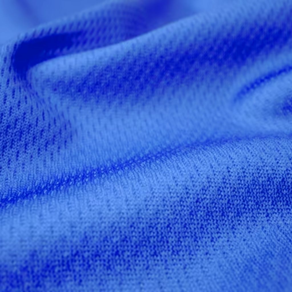 A close-up of textured fabric in blue tones, showing a smooth, soft weave with subtle folds.
Vapor Flow Athletic Fabric: