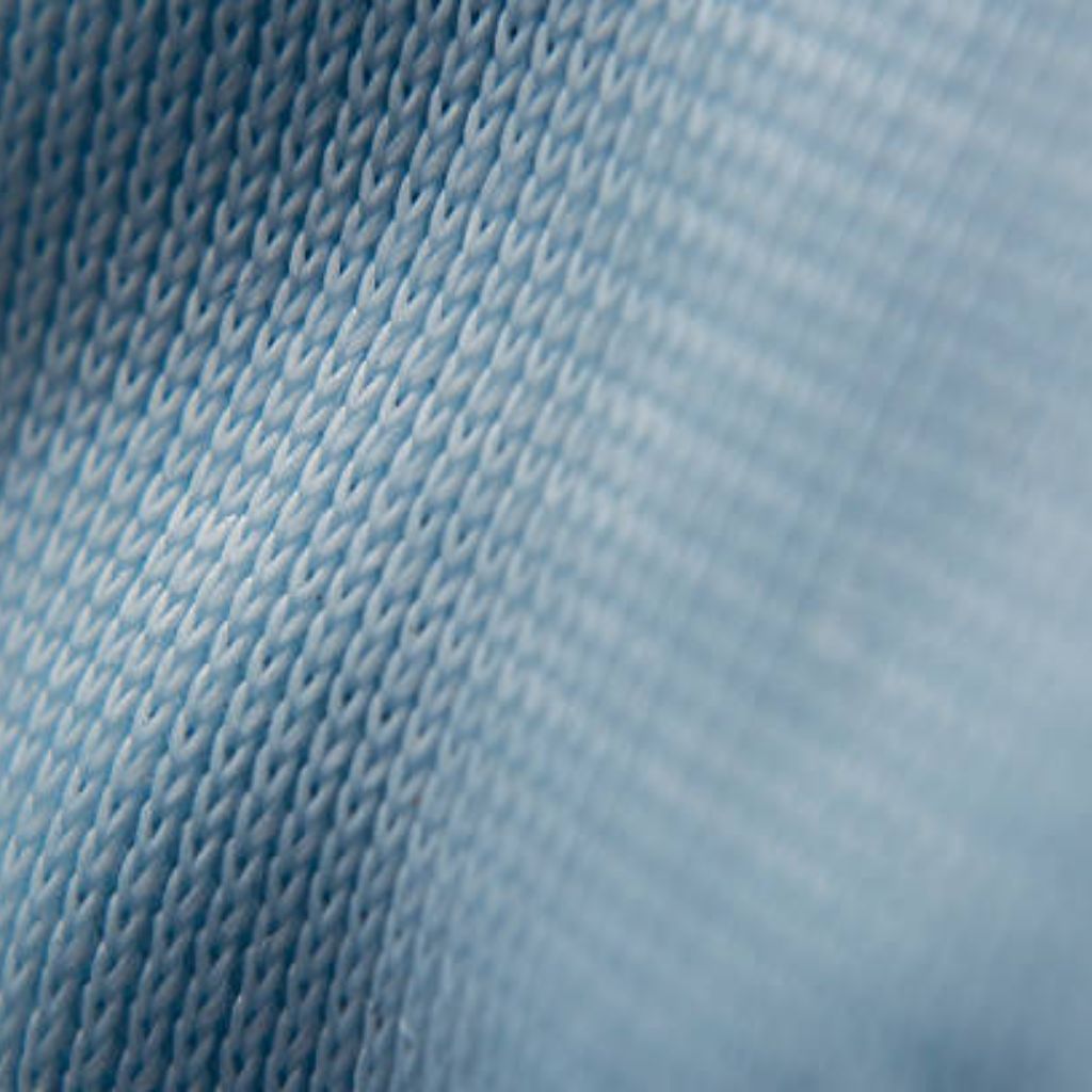 Alt text (long): Macro close-up of a blue knit fabric used in winter jackets, showing tightly woven diagonal ribbing, subtle sheen, and a rugged, durable texture suitable for outerwear.
Air Flex Knit Fabric: