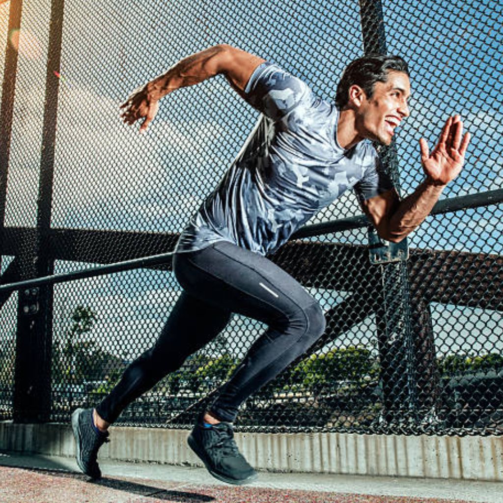 Kinetic Flow Athletic Fabric: Ultimate Comfort for Athletes 10 “A man in a gray-and-black camouflage athletic shirt and black leggings sprinting sideways across a bridge, with a chain-link fence and sunny sky visible.”
Kinetic Flow Athletic Fabric: