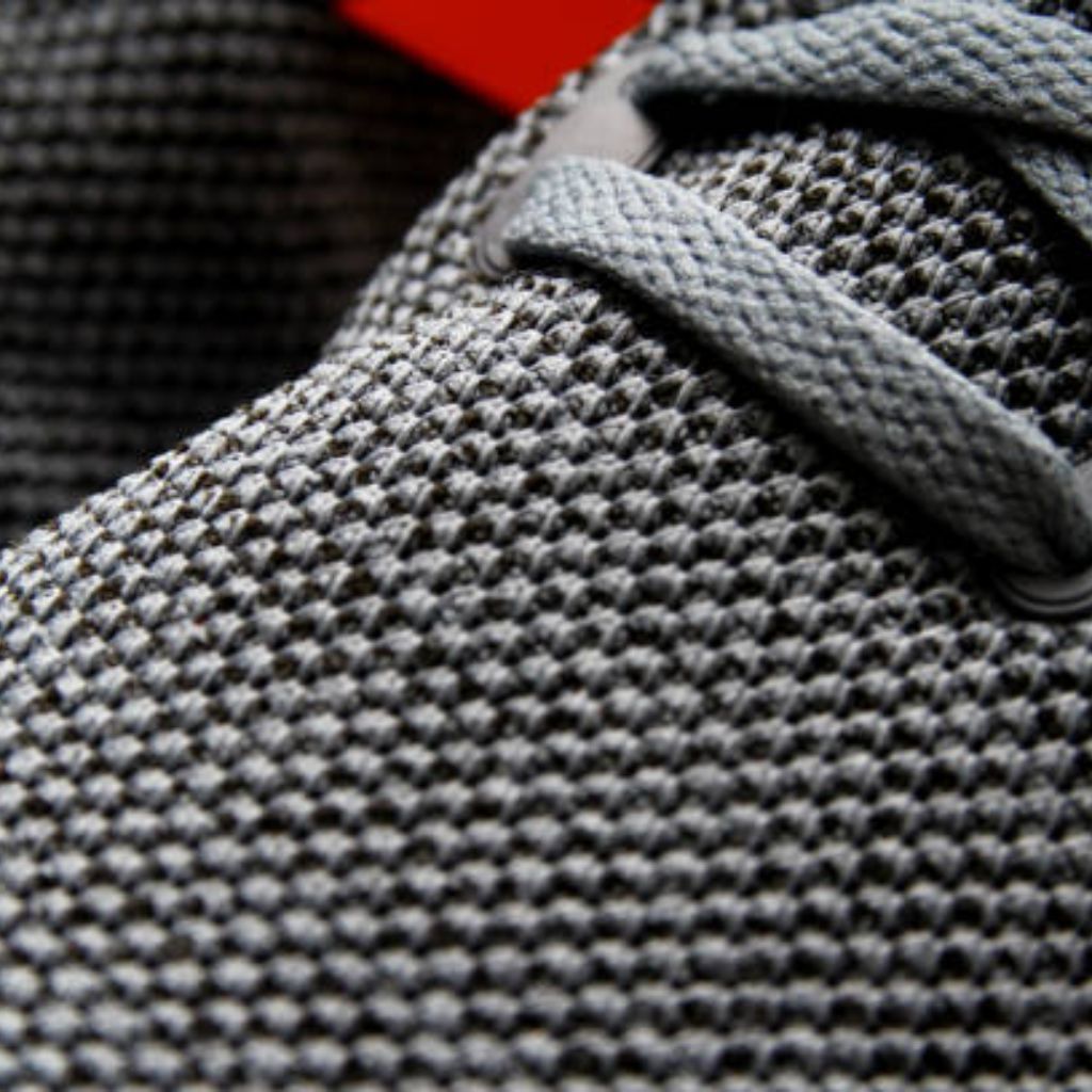 Hyper Flex Motion Knit: Engineered for Ultimate Flexibility 10 Close-up of a gray knit sneaker with textured mesh and laces.Hyper Flex Motion Knit:
