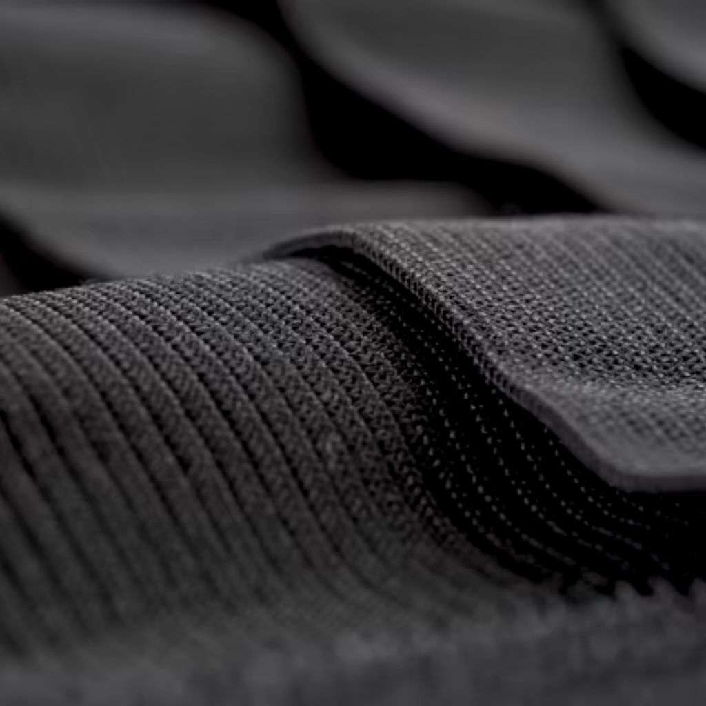 Long alt text: Macro close-up of blue knit fabric showing tight diagonal ribbing, a dense weave, and a rugged, durable texture typical of winter outerwear.
Air Flex Knit Fabric: