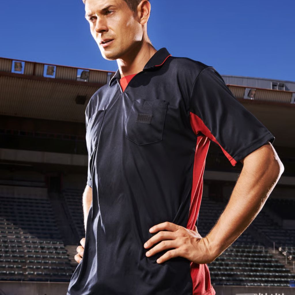 Velocity AirFlow Performance Knit: Breathable Sports Fabric 11 A man wearing a navy blue and red polo shirt stands with hands on hips in a stadium with blue sky background.
Velocity AirFlow Performance Knit: