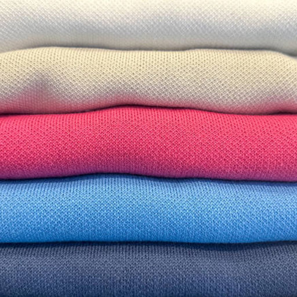 Close-up of stacked knit fabrics in neutral gray, pink, bright pink, blue, and navy, highlighting textured weaves and subtle color variation.

Polar Lite Cooling Knit:
