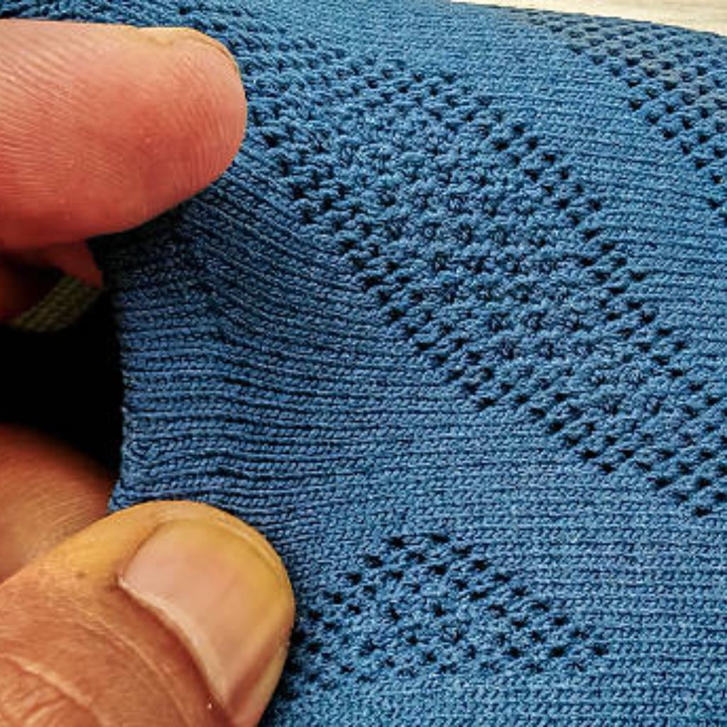 Hyper Flex Motion Knit: Engineered for Ultimate Flexibility 7 Close-up of blue textured knit fabric with visible woven pattern.Hyper Flex Motion Knit: