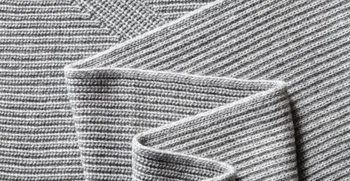 Ribbed Pure Cashmere Fabric Close-up of a folded gray ribbed cashmere fabric with thick yarn and visible knit texture.