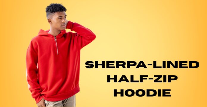 A young man wearing a red sherpa-lined half-zip hoodie stands against a warm yellow gradient background. He is touching the back of his head with one hand, looking to the left.