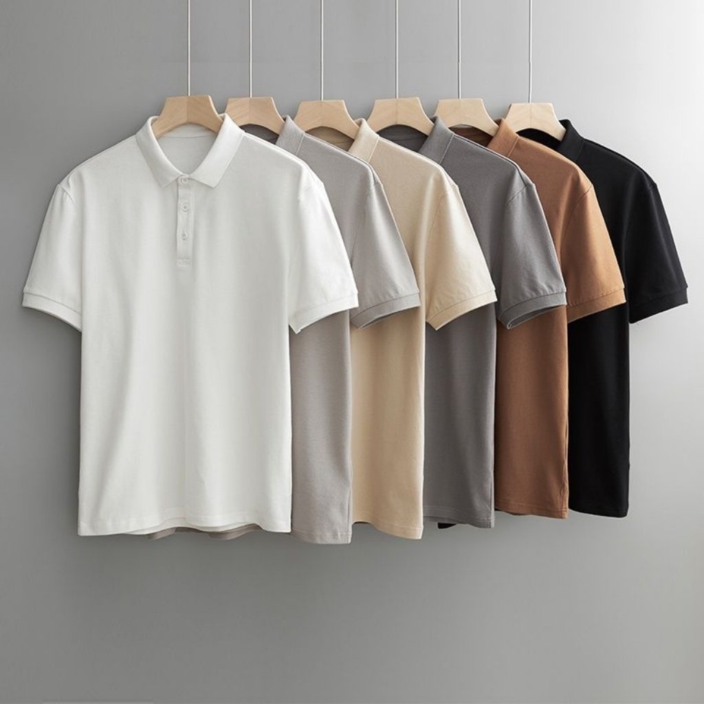 Half sleeve polo t-shirts in neutral and dark colors hanging on wooden hangers.

