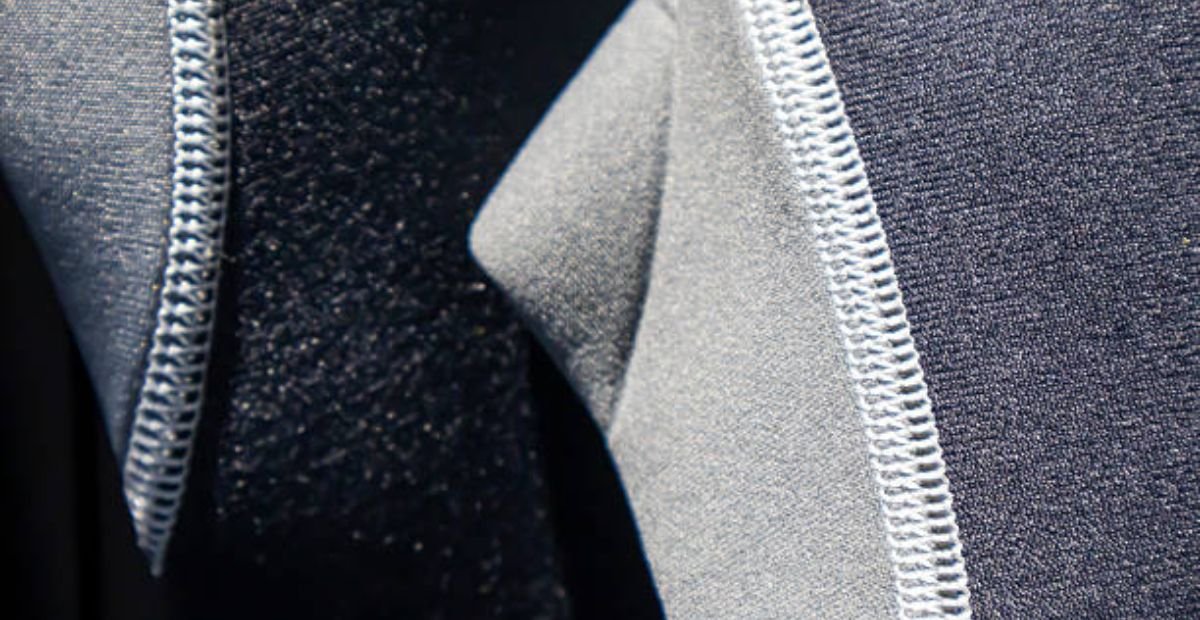 Neo Dry Tech Fabric: Ultimate Moisture Control for Athletes "Close-up of the interior construction of a blue and gray winter coat showing layered fabric textures, visible stitching, and quilted lining." Neo Dry Tech Fabric: