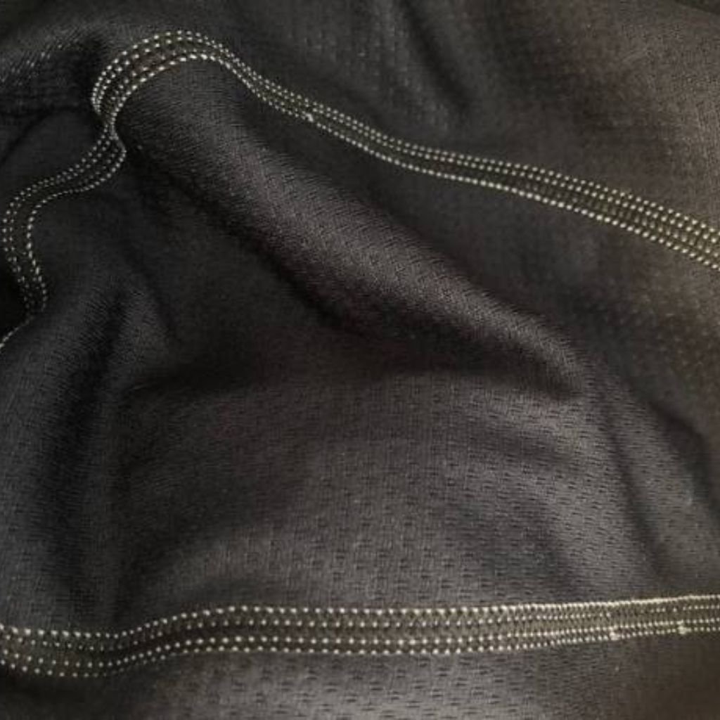 "Close-up of black woven fabric with subtle geometric pattern and diagonal contrast stitching, highlighting texture and construction detail."
Polar Air Breathable Fabric:
