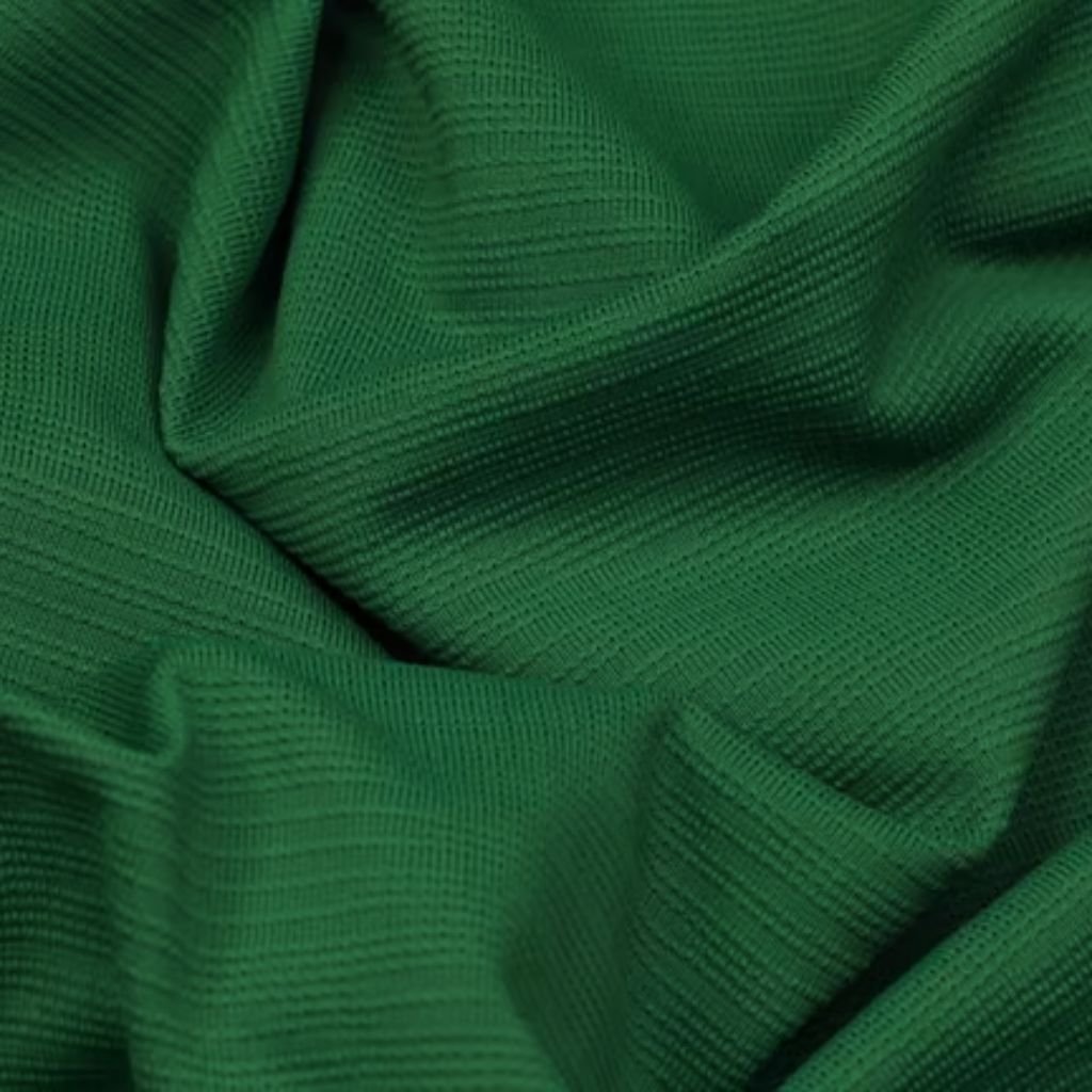 Green Flex Athletic Knit: Future of Eco-Friendly Activewear 9 Close-up of dark green waffle-weave fabric with visible texture, folds, and soft shadow-play — used in military-inspired winter jackets.
Green Flex Athletic Knit: