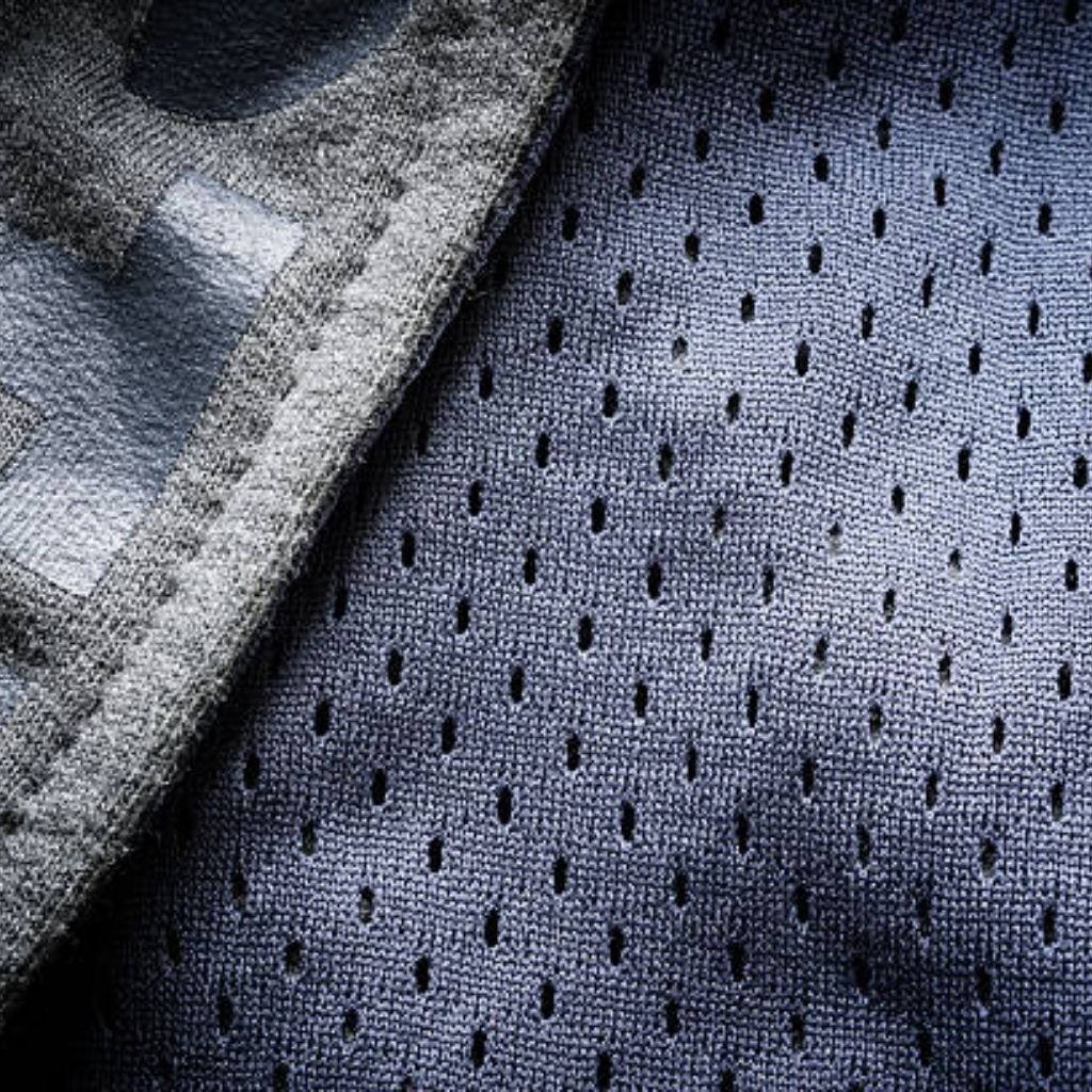
Close-up of a dual-texture technical knit: left, smooth solid gray fabric with fine yarn texture; right, same-gray fabric with evenly spaced micro-perforations. Subtle blue undertone throughout.

Dynamic Flex Sports Knit: