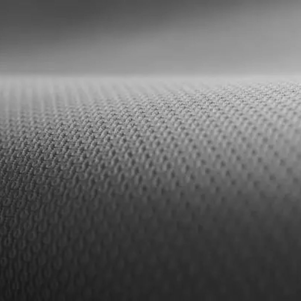 Infinity Dry Performance Fabric: Sweat-Wicking Comfort Gear 6 Macro view of grey fabric with a fine textured weave and smooth, slightly curved surface.Infinity Dry Performance Fabric:
