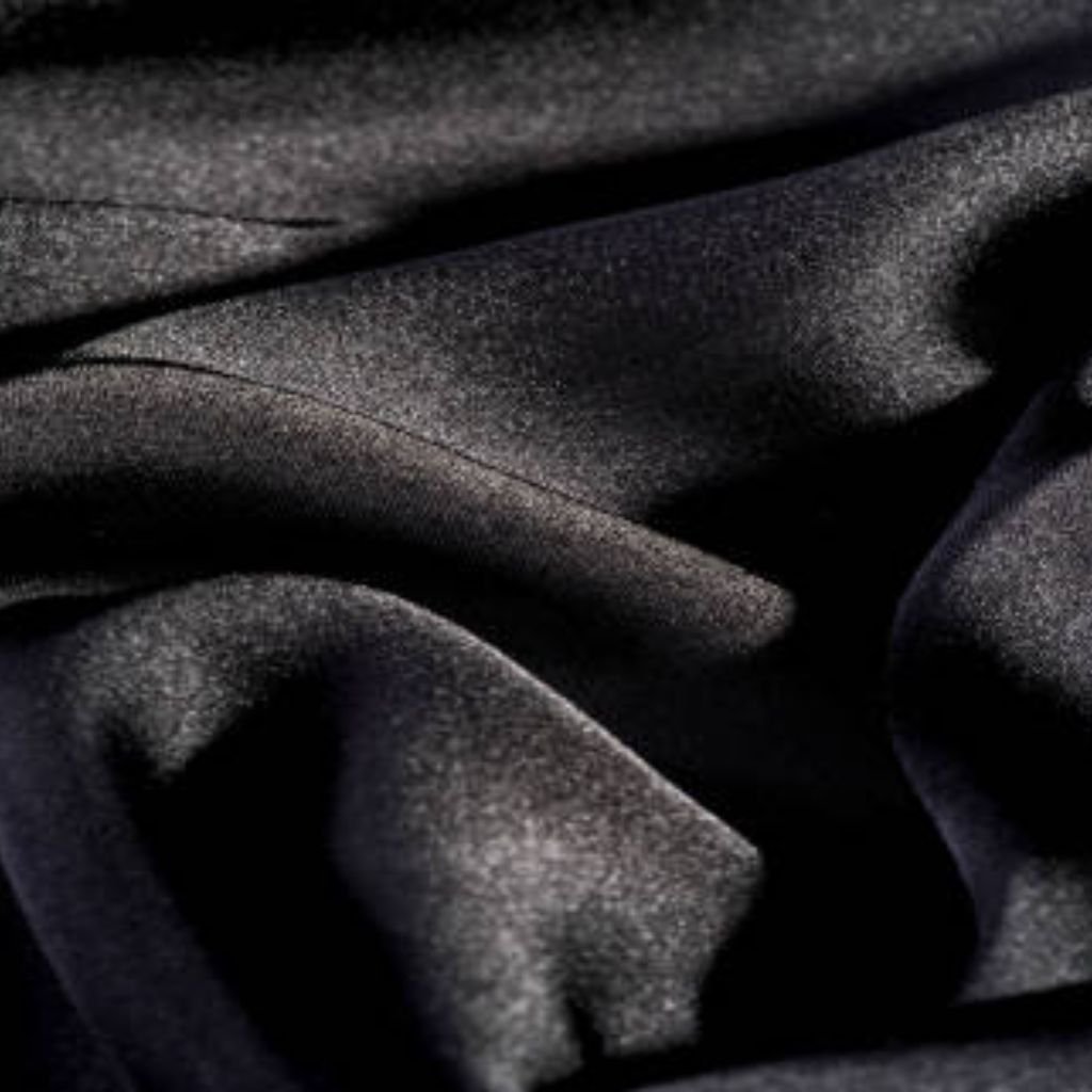 "Close-up of rich, dark fabric with deep folds and soft light reflections, suggesting a luxurious military-inspired winter jacket"
Power Stretch Elite Fabric:
