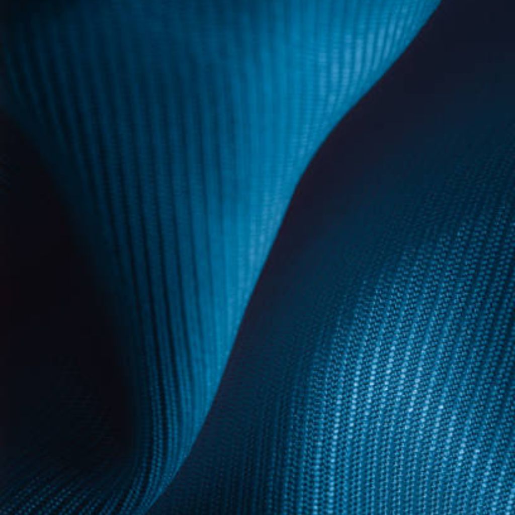 Close-up of folded light blue wool-blend fabric with fine diagonal rib weave, showing soft drape, subtle tonal variation, and crisp shadow contrast emphasizing three-dimensional texture.

Aqua Wick Performance Textile:
