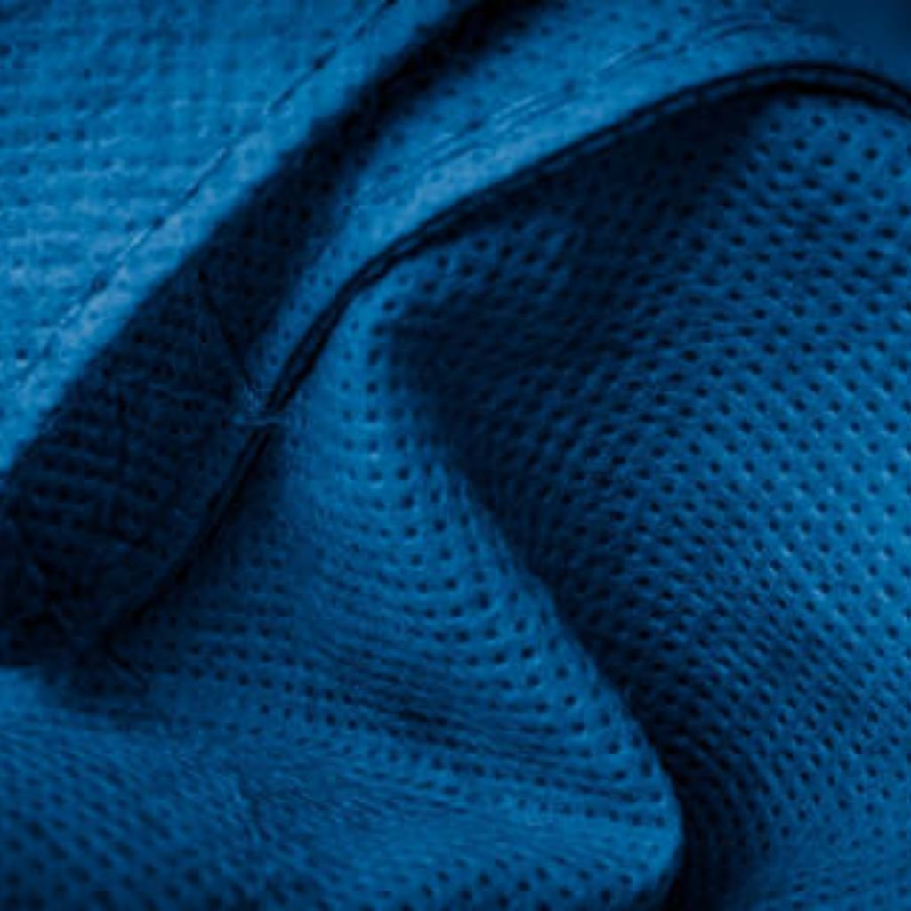 "Close-up of textured blue fabric with perforated surface and visible stitched seam, showing fabric folds and shadows"
Polar Air Breathable Fabric:
