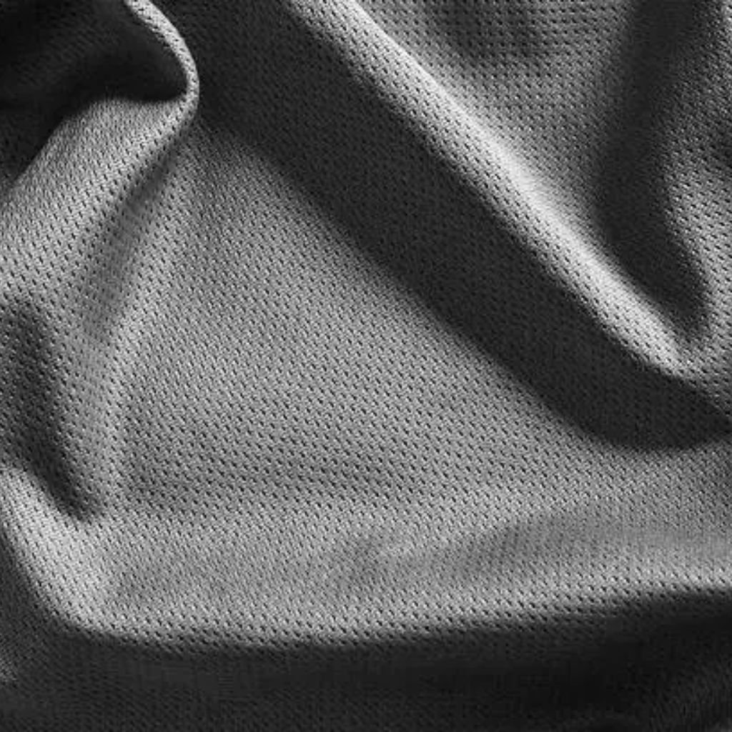 "Close-up of gray technical mesh fabric with uniform micro-perforations, showing soft folds and textured surface"

Turbo Dry Athletic Fabric: