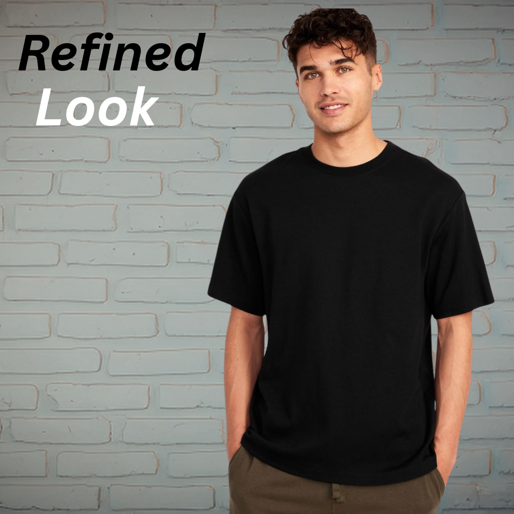 Modern Drop Shoulder Tee – Minimal Streetwear Look 10 Minimal streetwear drop-shoulder t-shirt in a solid black color, styled on a model against a light brick wall background.