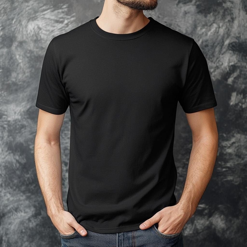 Man wearing a plain black t-shirt against a textured gray studio backdrop.

