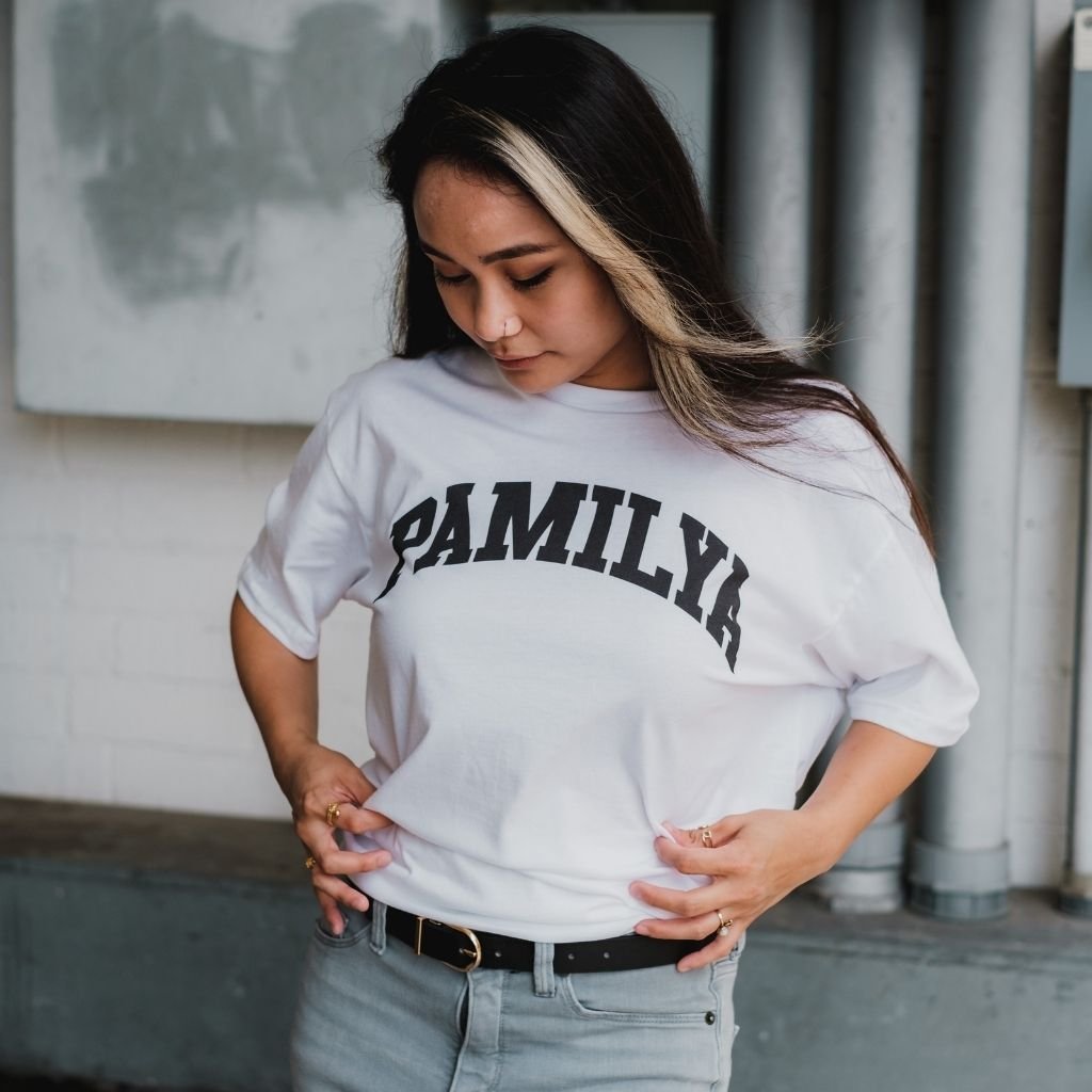 Woman modeling a white “VIRGINIA” graphic women’s T-shirt with long hair outdoors near a modern building.Women's T Shirts