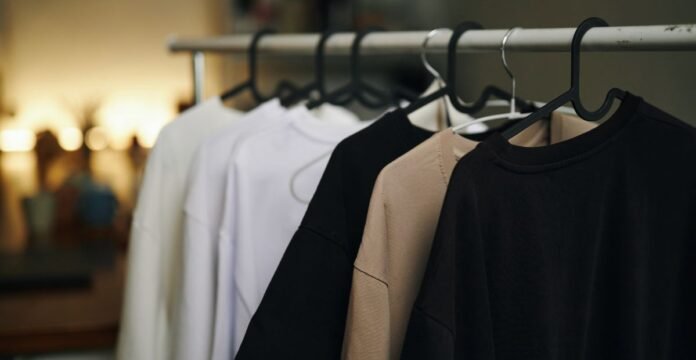 Daily style T-shirts hanging on a clothing rack—black, navy, beige, and white tees with a clean, minimal look.