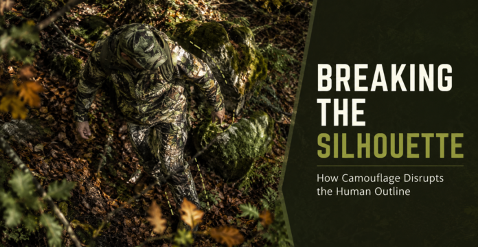 Overhead view of camouflage clothing disrupting a person’s outline against leaves, moss, branches, and rocks.