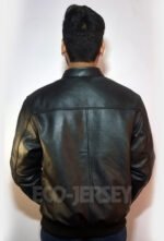 A young man standing with his back to the camera, wearing a stylish black leather jacket against a white background.
