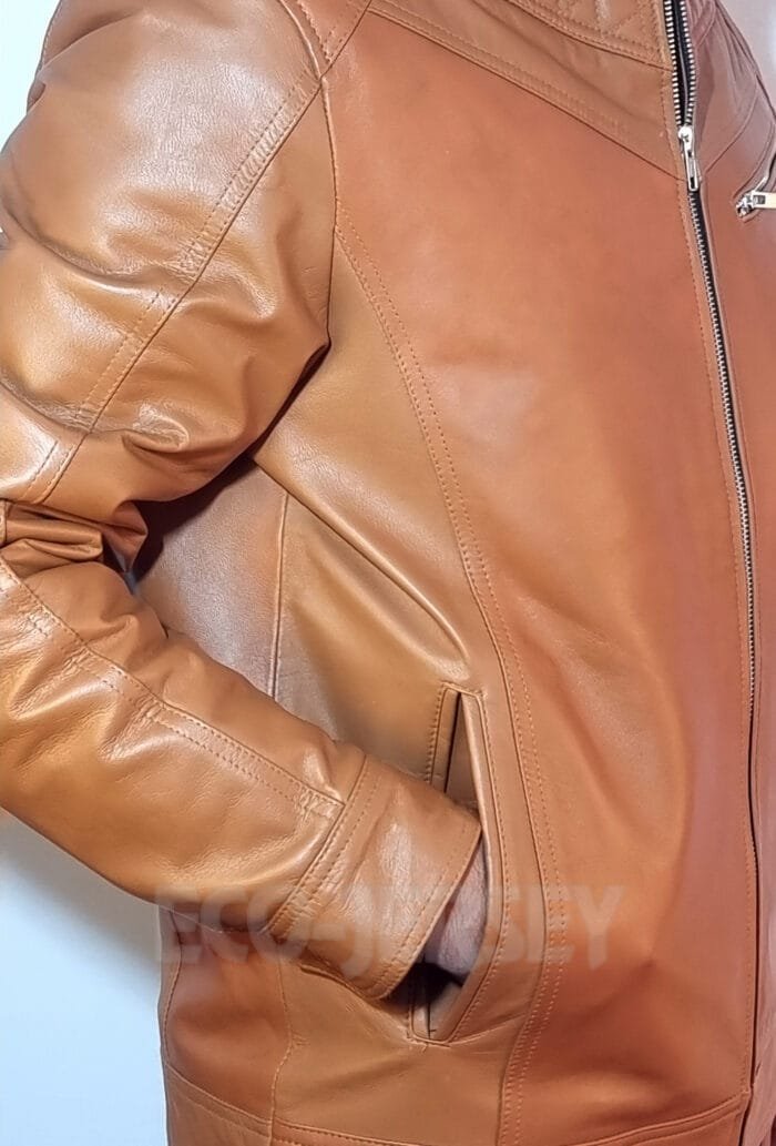 Close-up side view of a brown leather jacket, highlighting the stitching and side pocket design.