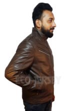 Close-up of a man's hand in the side pocket of a brown leather biker jacket.