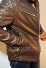 Detailed view of a zippered chest pocket on a brown leather motorbike jacket.