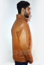 Side view of a young man wearing a brown leather jacket, showcasing quilted shoulder detailing and a high collar.