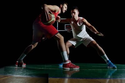 2 basketball players tring to get or snach the ball from one an other.