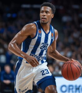 A male basketball player in a blue and white striped uniform dribbles a basketball on the court.