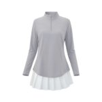 Light gray long-sleeve golf top with a mock neck and partial zipper, paired with a short white pleated skirt.