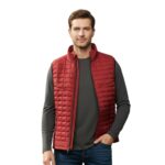 Men’s red quilted golf puffer vest worn over white polo shirt on golf course with clubs in background