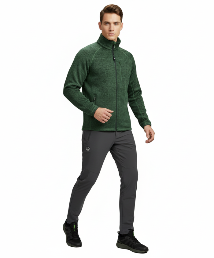 Man wearing a green fleece jacket and gray athletic pants, walking toward the right, on a white background.