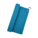 A light blue waffle-textured golf towel folded with a roll on the left and a silver carabiner on the top-right corner.