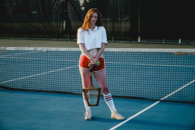A women standing by wearing Tennis Apparel.