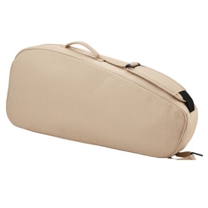 A beige tennis racket bag shown at a diagonal angle with a top handle and a shoulder strap. The surface has a subtle triangular pattern, and a buckle is visible on the strap.