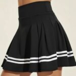 Black women’s badminton skort with pleated skirt and contrasting white stripe trim.