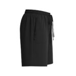 Side view of black women’s golf shorts with elastic waistband, drawstring, and a zippered pocket on the left with a nearby regular pocket.