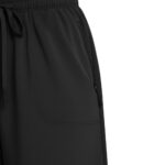 Close-up of left side of black golf shorts showing waist drawstring, large front patch pocket, and vertical side zip pocket.