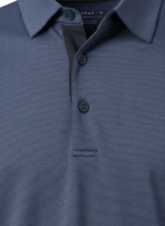 Close-up of a navy blue polo shirt showing a textured weave, collar with a button, and a dark placket underneath with three buttons.