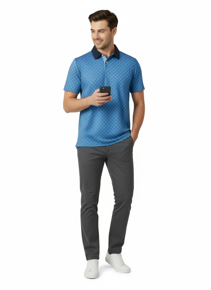 Man wearing a blue patterned polo shirt, gray pants, and white sneakers, standing against a white background while holding a phone.