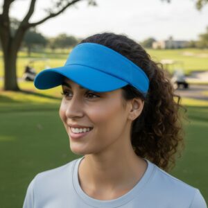 Smiling woman with curly brown hair wearing a blue golf visor on a golf course