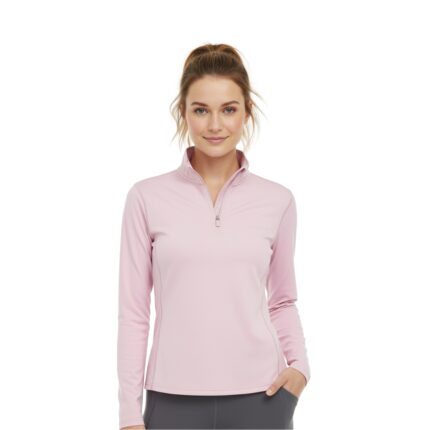Woman wearing a light pink women's golf quarter-zip top with long sleeves and a high collar, posing in gray pants.
